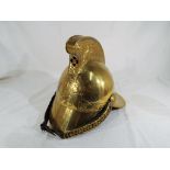 A Victorian brass Merryweather type Fireman's helmet having a leather and brass chin strap and