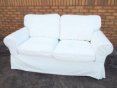 A contemporary white Ikea two-seater sofa, approximate height 90 cm x 180 cm x 82 cm.
