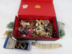 A box containing a quantity of vintage costume jewellery, brooches,