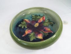 Moorcroft Pottery - a large Pottery footed bowl decorated with Clematis on a green ground,