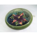Moorcroft Pottery - a large Pottery footed bowl decorated with Clematis on a green ground,