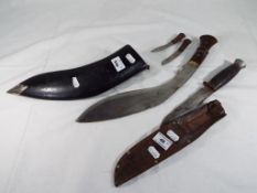 A well maintained Kukri knife with a small knife and sharpener in a wooden leather bound sheath