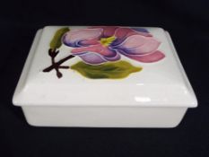 Moorcroft pottery - a rectangular Moorcroft pottery trinket box decorated with pink magnolia on a