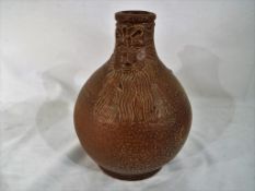 A 17th century dark brown salt glazed stoneware Bellarmine jug / flagon (lacking handle) bearded