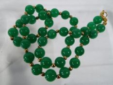 A yellow metal and green hard stone necklace - This lot MUST be paid for and collected,