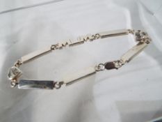 A silver bracelet with stone set heart and the word Mum incorporated,