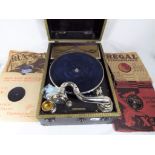 A wind up gramophone in carry case complete with four gramophone records and spare needles