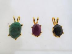 Three yellow metal pendants set with gemstones with certificates of authenticity.