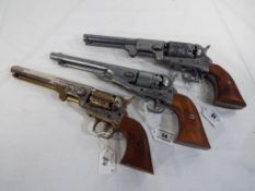 Three replica percussion pistols two in the form of Colt navy pistols and one in the form of a Colt