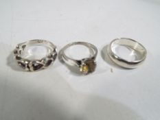 Three silver dress rings.