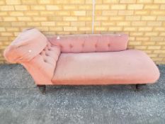 A Victorian upholstered chaise lounge on turned supports having original castors,