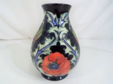 Moorcroft Pottery - A small Moorcroft pottery vase decorated with poppies on a blue ground,