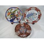 Three Asian plates comprising one in the Imari pattern with character marks to the base,