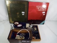 A wooden jewellery box containing a quantity of vintage costume jewellery to include brooches,