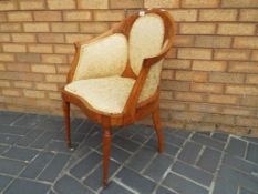 An antique satin wood inlaid salon chair having upholstered back and seat on turned frontal