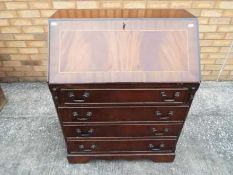 A mahogany slope-front bureau with pigeon-hole fitted interior above four drawers