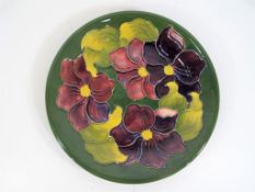 Moorcroft Pottery - A large Moorcroft pottery plate decorated with clematis on a green ground,