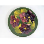 Moorcroft Pottery - A large Moorcroft pottery plate decorated with clematis on a green ground,