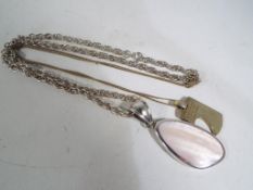 Two silver necklaces with pendants.