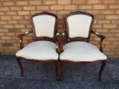 A matched pair of mahogany armchairs with padded, seats,