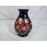 Moorcroft Pottery - A small Moorcroft pottery baluster vase decorated in the Freesia pattern on a