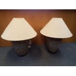 A matching pair of large stone urn table lamps with wooden bases decorated with a wicker surround,