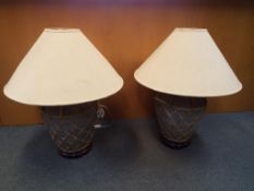 A matching pair of large stone urn table lamps with wooden bases decorated with a wicker surround,