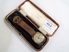 A lady's 9 carat gold cased wristwatch, assay mark for 1946, square form with silvered dial,