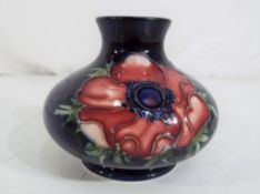 Moorcroft Pottery - A small Moorcroft pottery squat vase decorated with anemone on a blue ground,