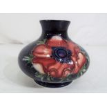 Moorcroft Pottery - A small Moorcroft pottery squat vase decorated with anemone on a blue ground,