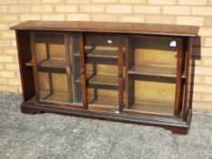 An oak bookcase with sliding glass doors,