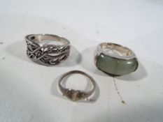 Three silver dress rings to include one stone set with jade.
