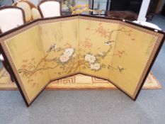 A four panel Oriental wooden framed screen depicting flowers and birds,
