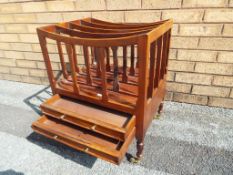 A mahogany magazine rack with four compartments and two lower drawers,