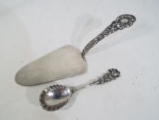 A silver cake slice with pierced decorat