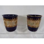 Royal Doulton - a pair of Royal Doulton stoneware vases with relief decoration and gilded