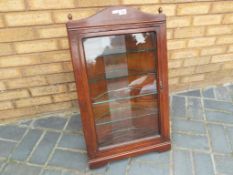 A mahogany glass fronted wall corner unit with glass shelves approx 80cm (h) x 48cm (l) x 20cm (w)