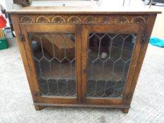 An oak cased two-door glass display cabinet with astral glazed doors,