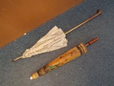 Two parasols, the larger a vintage example with wooden handle, white metal ferrule,