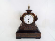An unusual French mantel clock with inlaid Arts & Crafts style decoration, brass finials,