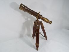 A brass telescope on wooden tripod stand.