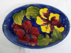 Moorcroft pottery - A small oval tray by Moorcroft pottery in the Hibiscus pattern on a blue ground,