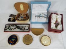 A small quantity of costume jewellery and four vintage powder compacts.