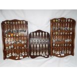 Three wooden wall mounted display cases containing sixty plated souvenir spoons (3) This lot MUST