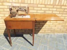 A mahogany cabinet containing a vintage Singer sewing machine This lot MUST be paid for and