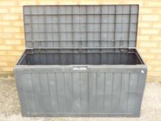 A hinge-lidded plastic moulded garden storage box,