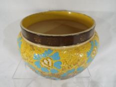 Royal Doulton - a Royal Doulton stoneware jardiniere with relief decoration and gilded highlights,