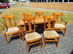A contemporary dining table with four chairs and two carvers,