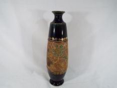Royal Doulton - a Royal Doulton Lambeth Ware vase decorated on a green ground with relief