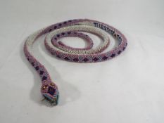 A World War One (WW1) Turkish prisoner-of-war bead snake, worked in pink,